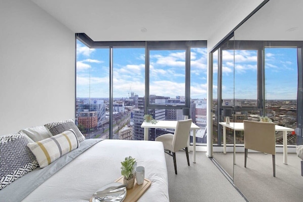 The master bedroom with a queen sized bed & a view over the city.