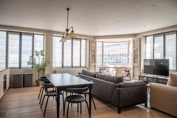 Open concept living room and dining room area - complete with sofa coach, smart TV and area rug.