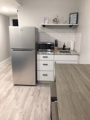 Kitchenette with fridge, sink, and microwave  