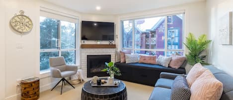 A spacious living room that can seat 4 guests while enjoying the view outside and warmth from the fireplace