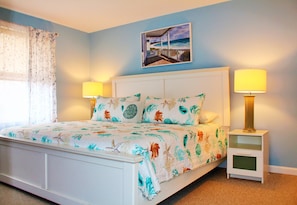 Master bedroom - King bed with linens and pillows. Ample lighting, TV & dresser.