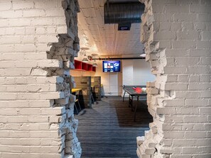 Fun character and details throughout the space.  Behind this broken brick entry sits  a recreation room complete with 4 desks (a work-from-home dream!), a ping pong table and more.