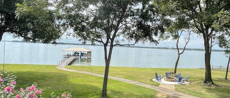 view from deck of fire pit, lake and pier and boathouse