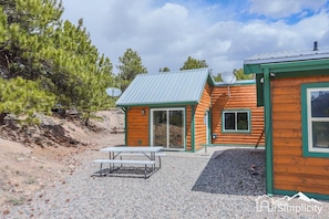 The exterior of our Trout cabin with picnic seating just outside your door.