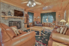 Large stone, gas log fireplace in the living room