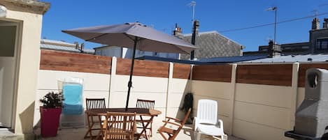 Terrasse bien exposée , à l'abris du vent avec barbecue privé et salon de jardin