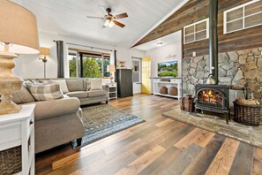 Family room has comfortable sectional sofa, Smart TV, wood burning stove