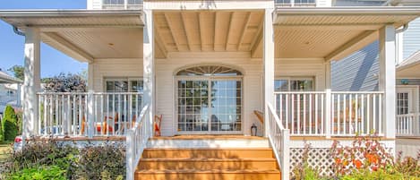 Large, waterfront home with balcony and patio at the front