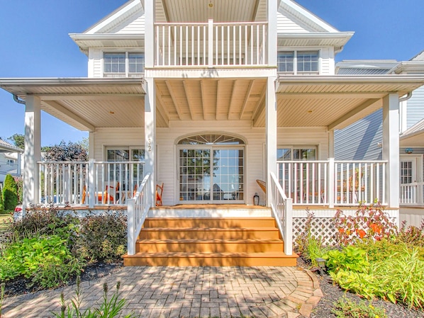 Large, waterfront home with balcony and patio at the front