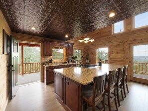 The kitchen features a granite island w/ built-in oven, range and microwave.