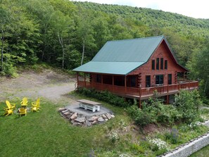 The chalet features a fire pit, outdoor dining table, propane grill and deck.