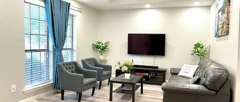 Unit 1 - Living room with smart TV, sofa, board games. 