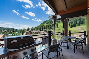 Deck with BBQ Grill, dining table, space heater with views of the pool, slopes and mountains