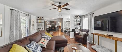 Cozy living room with tv, leather couch, and seat