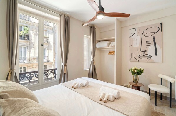 The spacious bedroom full of light with ceiling fan and storage for your belongings.