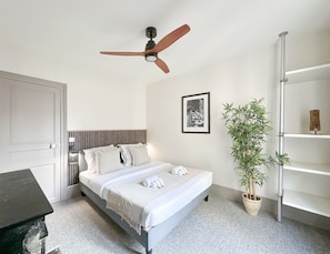 Spacious bedroom with a queen-size bed, ceiling fan, and ample storage.