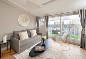 Living room includes a sofa and balcony regarding the neighborhood.