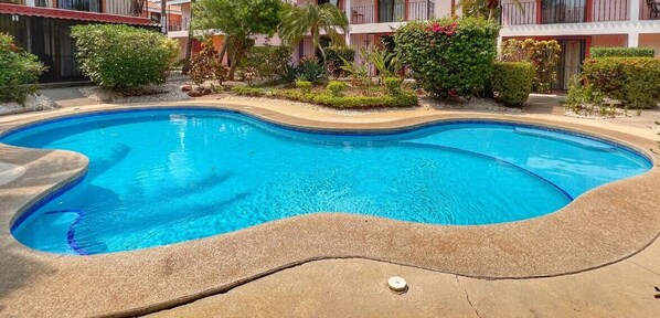 Unit #5 overlooks the tropical grounds of the small complex and community pool.  