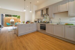 The Coach House, Cromer: A well-equipped kitchen/ dining area opens up into a light and airy sitting room with bi-fold doors overlooking the sunny courtyard