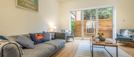 The Coach House, Cromer: Sitting room with bi-fold doors to small enclosed courtyard