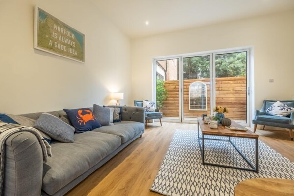 The Coach House, Cromer: Sitting room with bi-fold doors to small enclosed courtyard