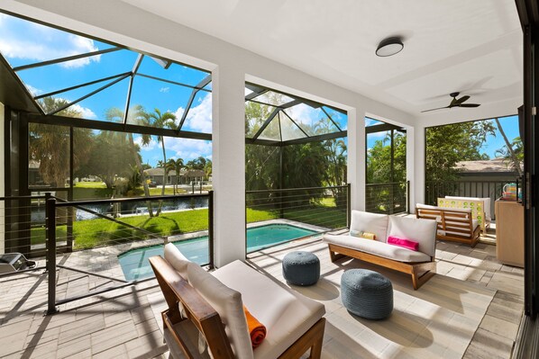 Pool with lanai sitting area and canal view
