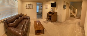 Downstairs living area with smart TV and roll top desk.