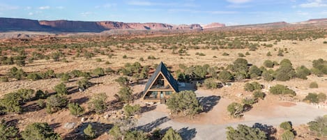 Drone shot of the Juniper House with Capitol Reef in distance