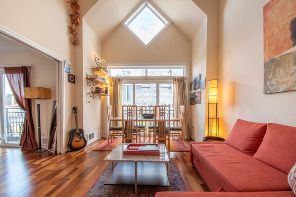 Spacious living room with sleeper sofa, dining table, fireplace and smart TV.