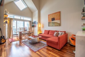 Spacious living room with sleeper sofa, dining table, fireplace and smart TV.