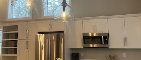 Kitchen with island seating for four and Bosch stainless steel appliances.