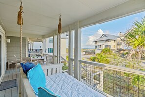 Spacious balcony with comfortable seating and a dining area, ideal for outdoor meals and relaxation.