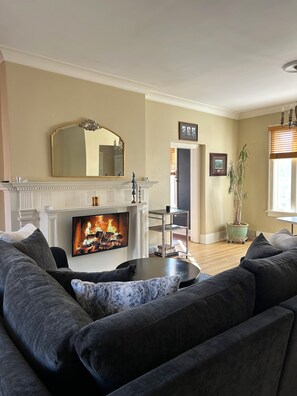 Light-filled living room with L-shaped sofa. New Mini-split HVAC.
