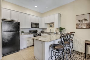 The fully-equipped kitchen features stunning appliances such as a Maytag top freezer refrigerator.