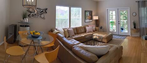 Open living design with plenty of FL sunshine, 60 in smart TV, and leather couch