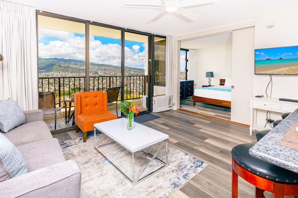 Living room with a pull-out sofa, chair, 43" TV, and mountain views