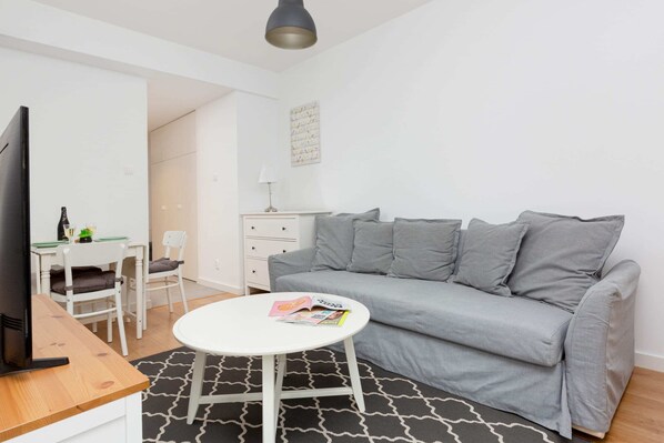  Spacious living area featuring a modern gray sofa and natural light.