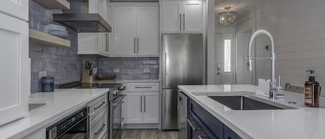 The beautiful renovated kitchen with white cabinets is a perfect spot for meal preparation.