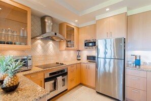 The kitchen features all stainless steel appliances, a microwave, stove, oven, dishwasher and fridge/freezer