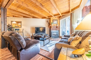Cozy living area with flat screen TV, gas fireplace, ample seating and access to the private back deck.