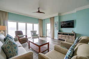Living Room | Breathe Easy Rentals - Plenty of seating for both comfort and views. Easy access to the private balcony where you can breathe in the clean ocean air. Flat screen tv with cable and wifi for your indoor entertainment.