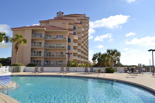 Resort-style pool with spacious deck, lounge chairs, and palm tree views — perfect for relaxing under the Florida sun.
