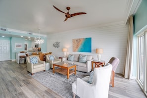 Living Room | Breathe Easy Rentals - New shiplap wall with deco artwork, a comfy double sleeper sofa bed, a  ceiling fan for those warm summer evenings and a gorgeous view for those awesome sunrises and sunsets.