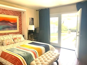 Primary bedroom with bathroom and French doors to walled backyard.