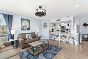 The living room leads to the dining table and kitchen. 