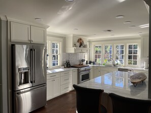 Large gourmet kitchen with open seating and all utensils needed for meals. 