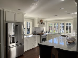 Large gourmet kitchen with open seating and all utensils needed for meals. 