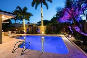 Relax poolside under the colorful landscape lighting at night!