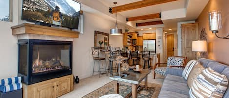 Living Room with plush sofa and lounger, gas fireplace, 55" TV, private patio access and breath-taking views of the Swaner Nature Preserve