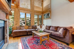 Living Room with plush leather furnishings, 40" TV, gas fireplace, and stunning floor to ceiling windows